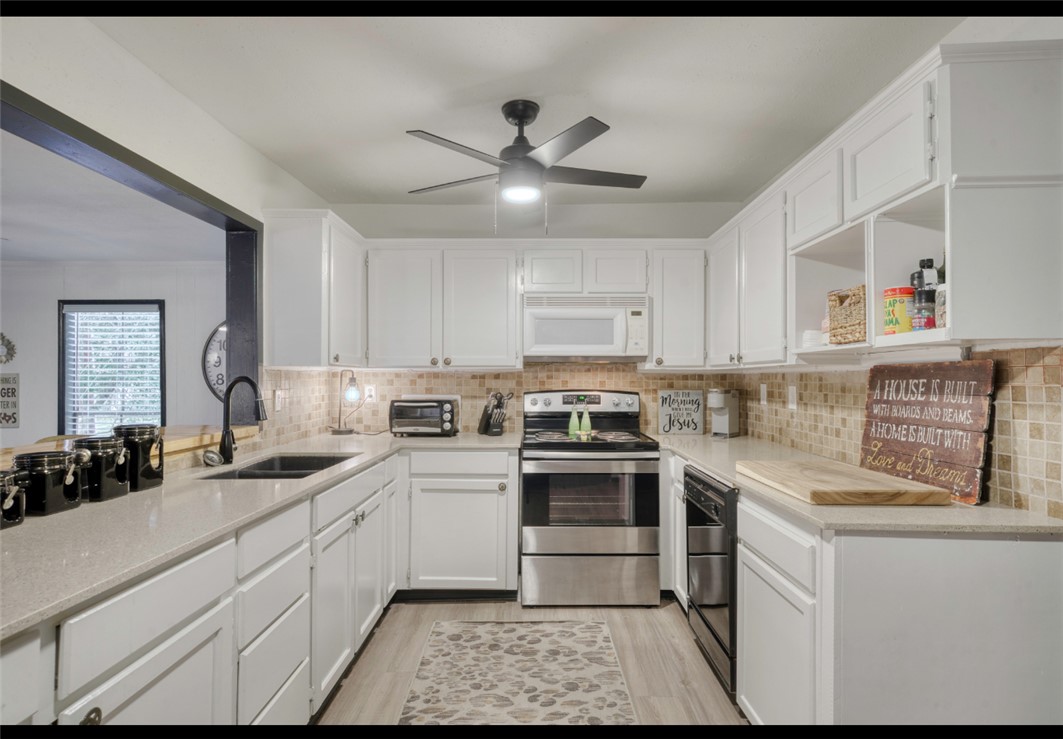 10967 Clyde Acord Road Franklin, TX 77856 - Photo 17 of 50 Kitchen featuring sink, light hardwood / wood-style flooring, ceiling fan, stainless steel electric range oven, and white cabinetry