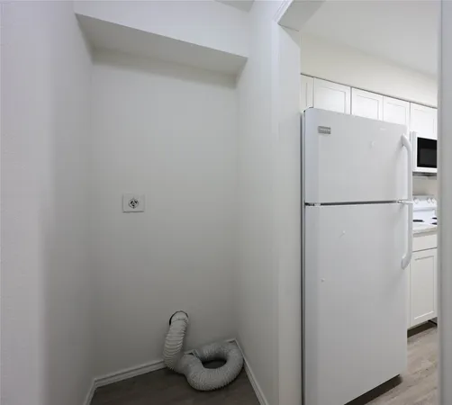 a white refrigerator freezer and a wooden floor