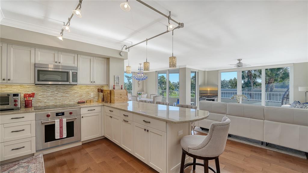 775 Longboat Club Road, Unit 204 Longboat Key, FL 34228 - Photo 17 of 40 a kitchen with stainless steel appliances granite countertop a sink a stove and a wooden floors