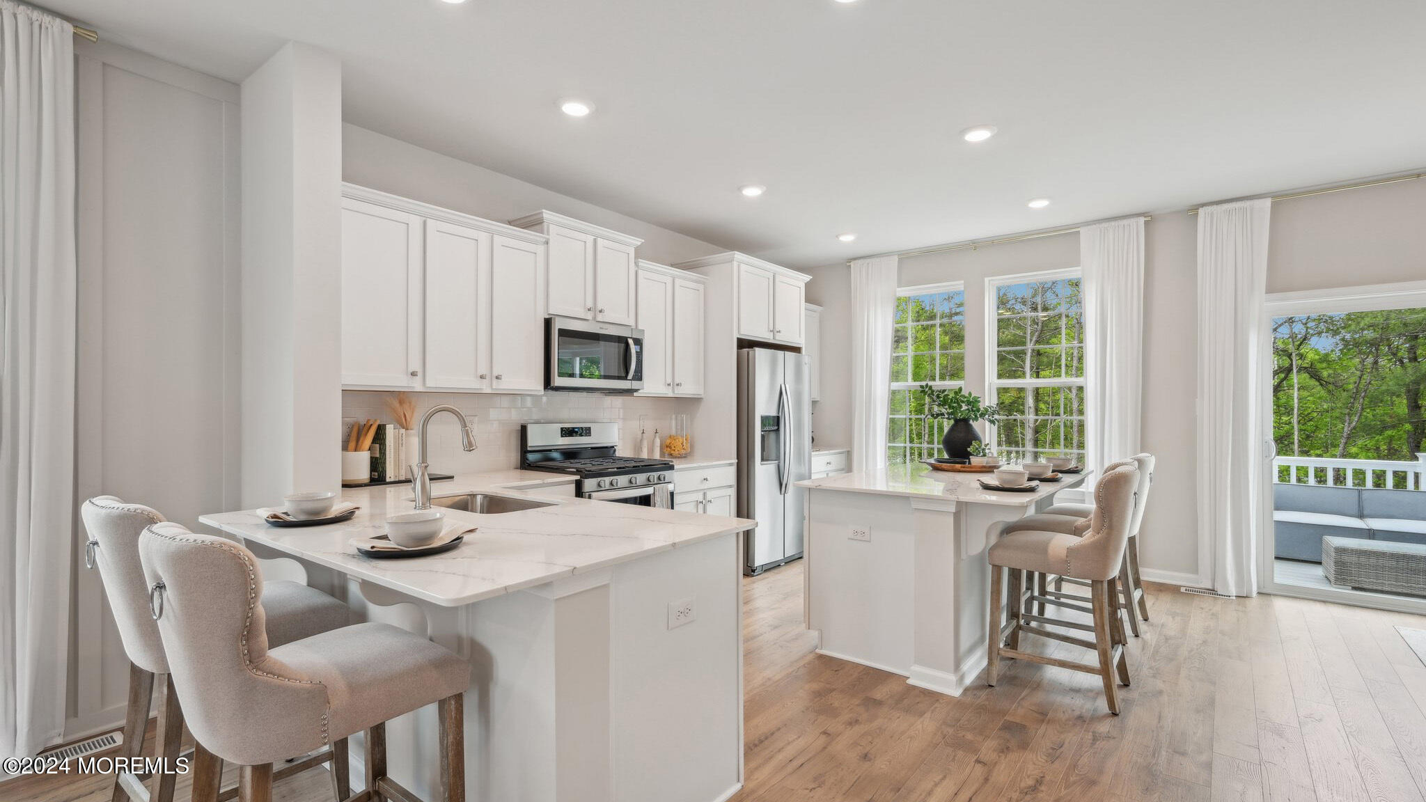 10 Rothbury Court Tinton Falls, NJ 07753 - Photo 17 of 43 a kitchen with a stove a sink a dining table and chairs