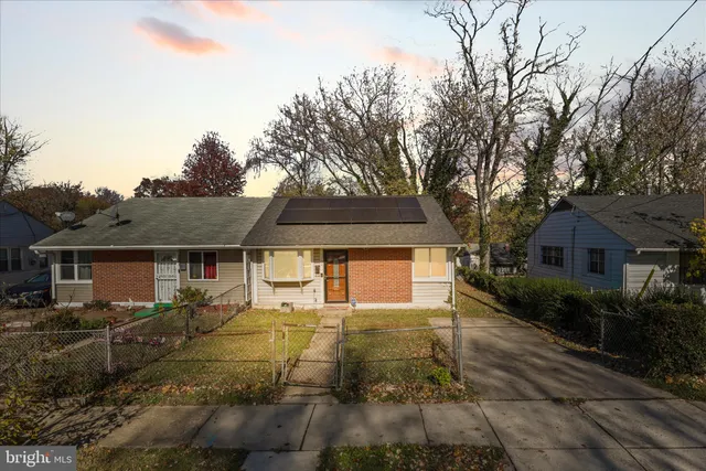 a front view of house with yard and trees around