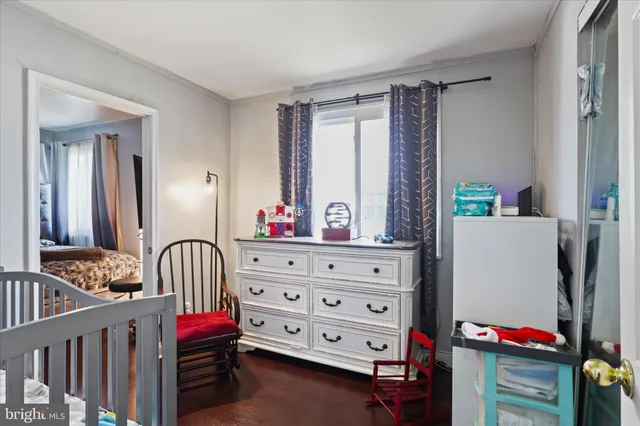 a living room with furniture and a baby crib