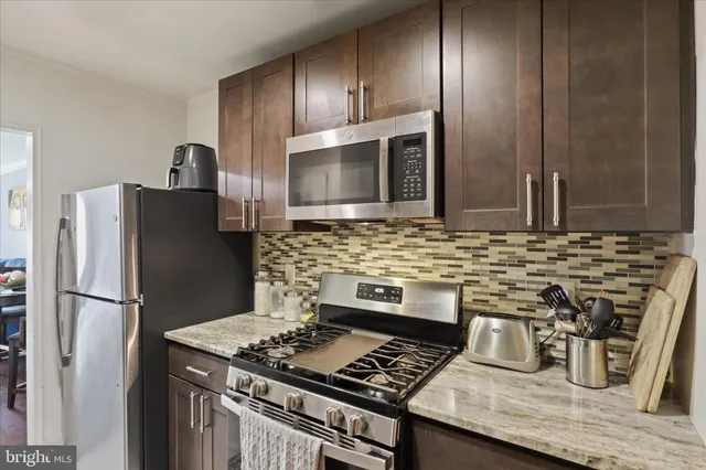 a kitchen with granite countertop stainless steel appliances and wooden cabinets