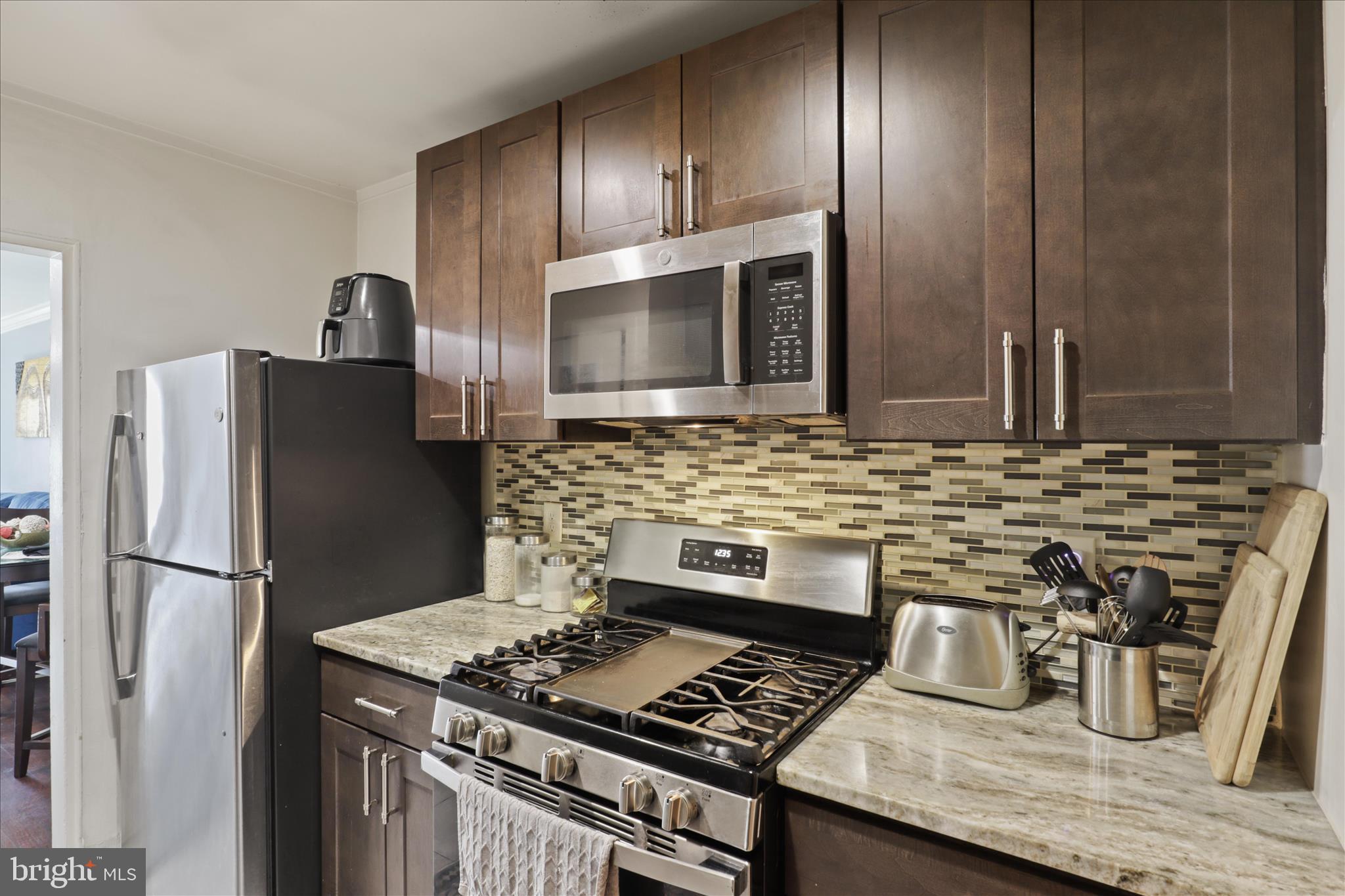 7750 Normandy Road Landover, MD 20785 - Photo 9 of 27 a kitchen with granite countertop stainless steel appliances and wooden cabinets