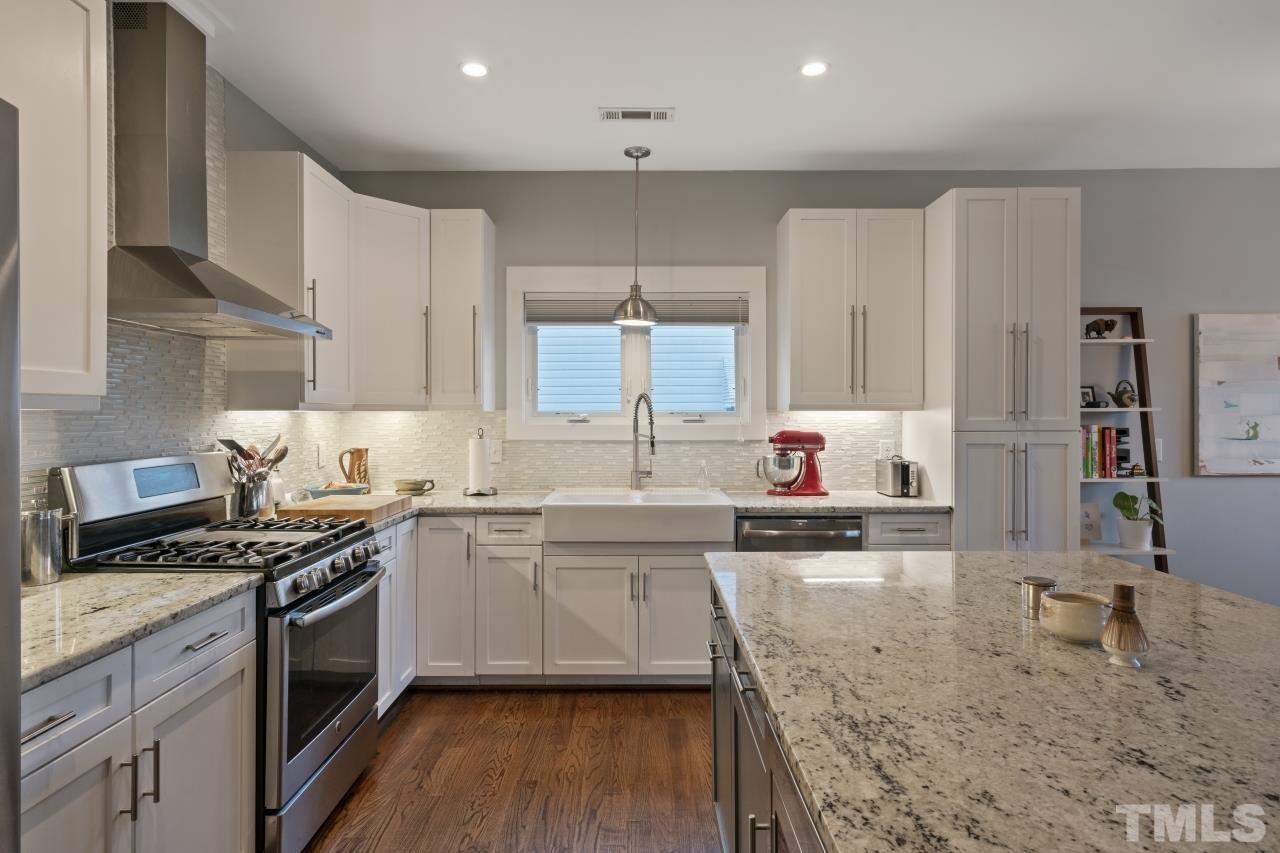 701 Colleton Road Raleigh, NC 27610 - Photo 14 of 39 a kitchen with stainless steel appliances granite countertop a stove a sink and a wooden cabinets