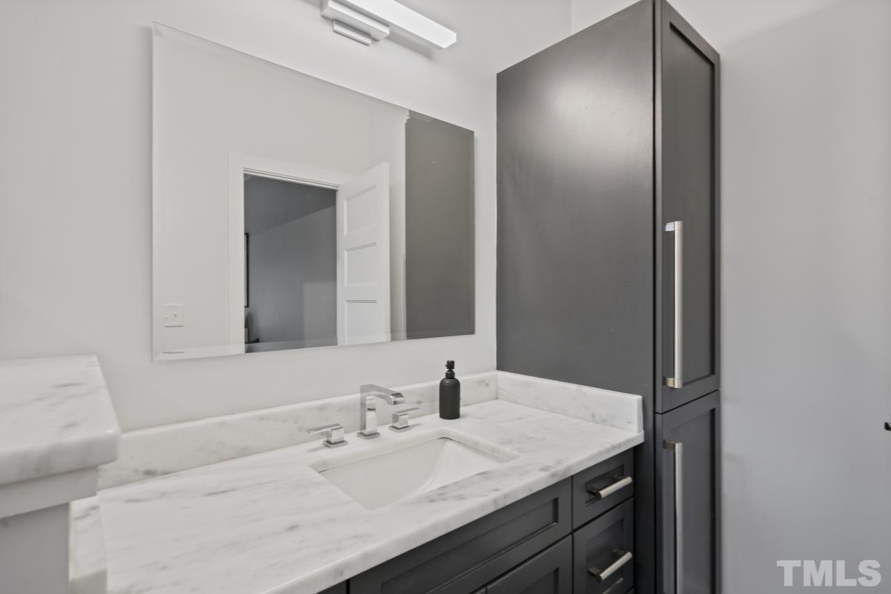 701 Colleton Road Raleigh, NC 27610 - Photo 21 of 39 a bathroom with a granite countertop sink and a mirror