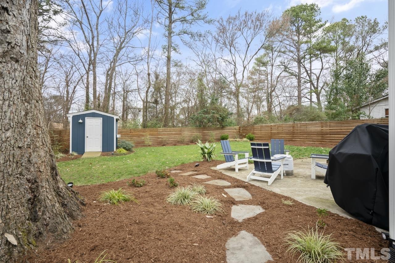 701 Colleton Road Raleigh, NC 27610 - Photo 36 of 39 a view of a backyard with table and chairs and a barbeque
