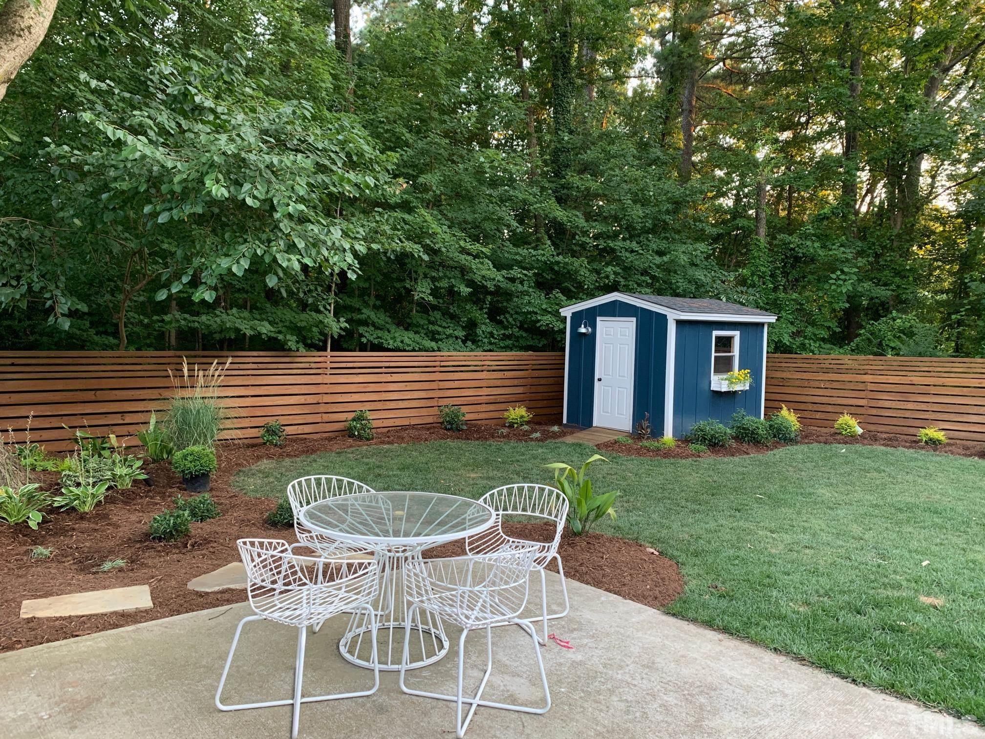 701 Colleton Road Raleigh, NC 27610 - Photo 38 of 39 a patio with table and chairs and potted plants