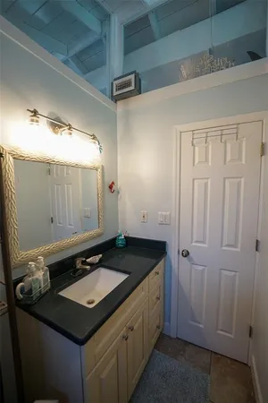 a bathroom with a granite countertop sink and a mirror