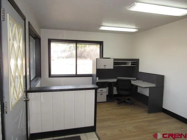 a view of workspace with wooden floor windows