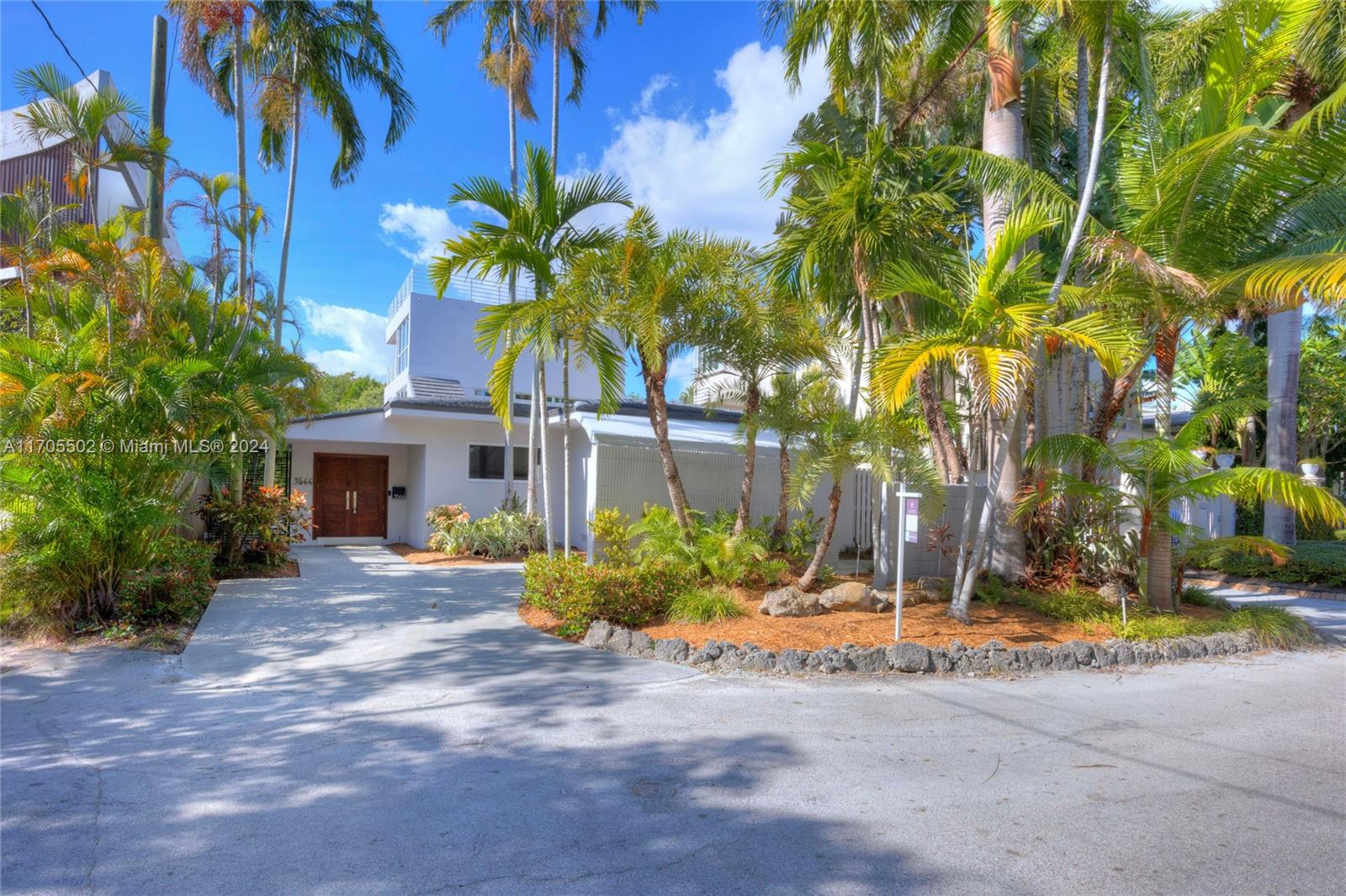 3566 Rockerman Road Miami, FL 33133 - Photo 2 of 43 a view of a house with a small yard and large trees