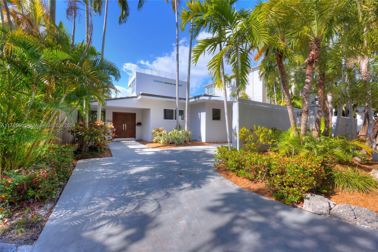 3566 Rockerman Road Miami, FL 33133 - Photo 3 of 43 a view of a white house with a yard and plants