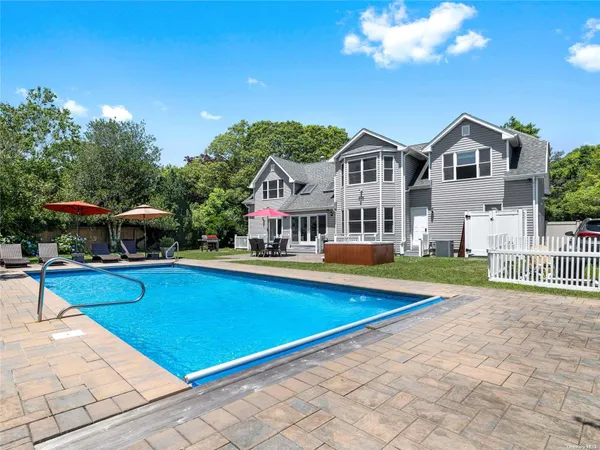 a view of a house with swimming pool and sitting area