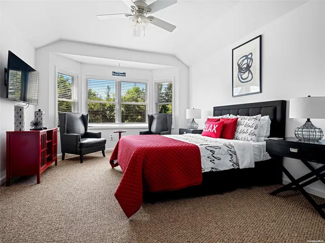 a spacious bedroom with a bed and glass windows