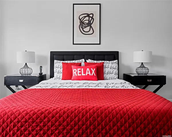 a bed sitting in a bedroom and a night stand