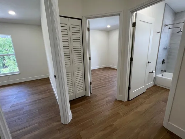 a view of a hallway with wooden floor and stairs