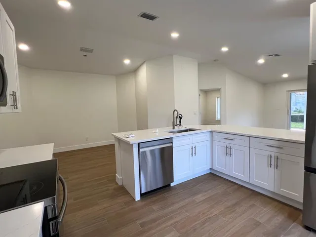 a large kitchen with stainless steel appliances wooden floors and wooden cabinets
