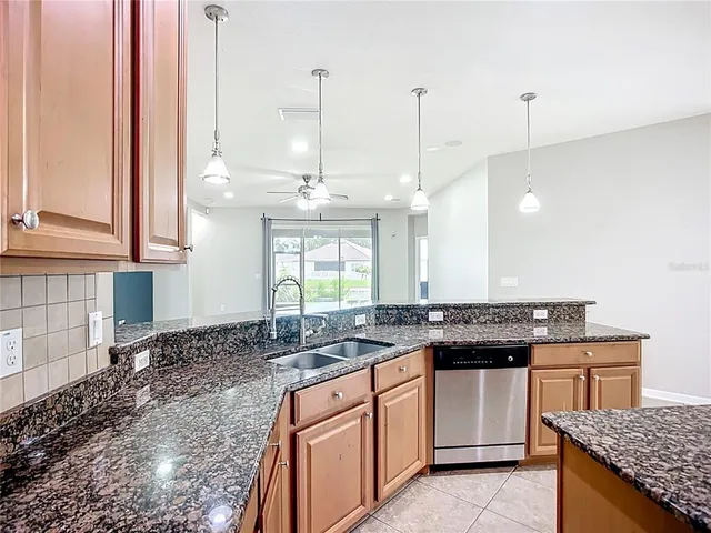 a kitchen with stainless steel appliances granite countertop a stove a sink and a refrigerator