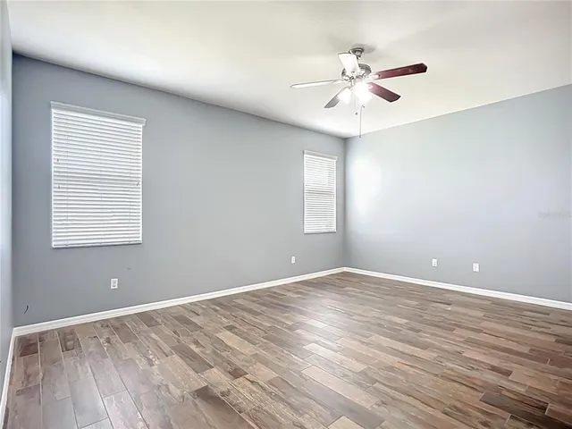 a spacious bathroom with a granite countertop sink a toilet and a mirror