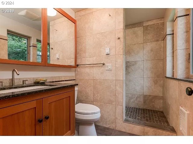 36245 Wagner Lane Cottage Grove, OR 97424 - Photo 39 of 45 a bathroom with a granite countertop sink a toilet a mirror and shower