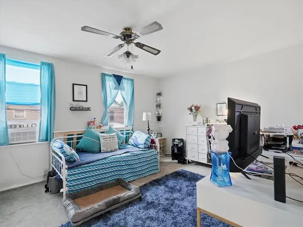 a living room with furniture a flat screen tv and a window
