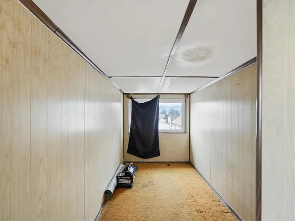 a view of a hallway with wooden walls