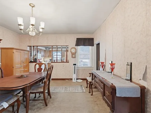 a view of a dining room with furniture and a chandelier