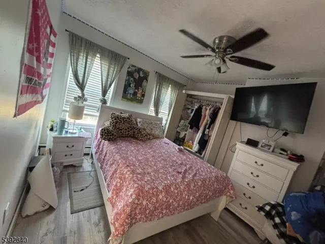 a bedroom with a bed and a flat tv screen on dresser