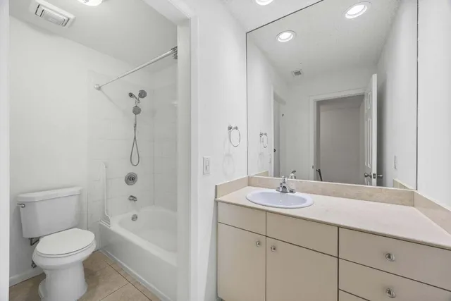 an empty room with windows and chandelier fan