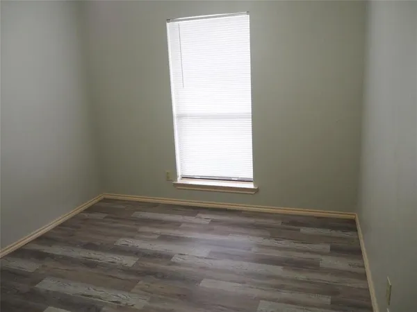 a view of a small space with wooden floor and a window