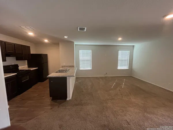 a view of kitchen with kitchen island wooden floor sink and refrigerator