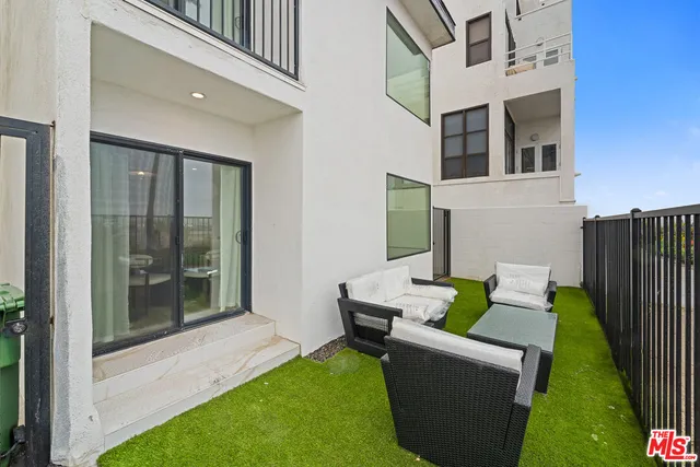 a view of an house with backyard and furniture