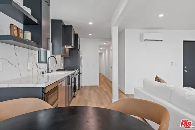 a large kitchen with stainless steel appliances a large counter top a stove and a refrigerator