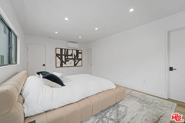 a bedroom with a large bed and a chandelier