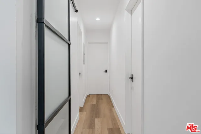 a view of a hallway with wooden floor and staircase