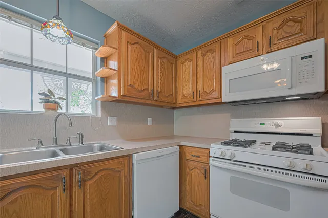 a kitchen with a sink a stove and cabinets
