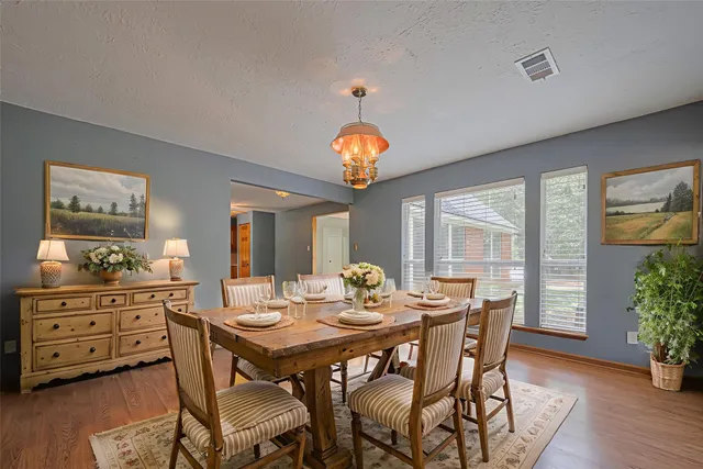 a view of an empty room with window and chandelier fan