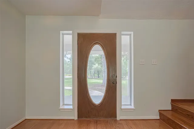 a view of a livingroom with wooden floor and a window