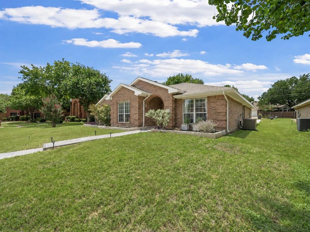 204 Arbor Ridge Drive Allen, TX 75002 - Photo 3 of 36 Brick exterior featuring an arched entry, multiple windows with white grid patterns, and a neatly manicured lawn