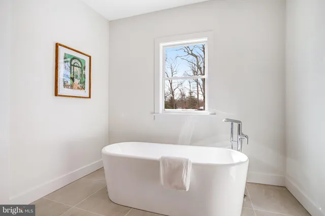 a bathroom with a bathtub and a window