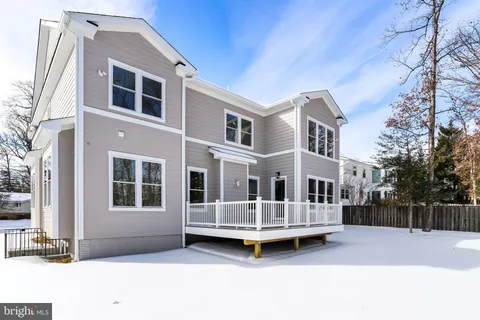 a view of a house with a wooden deck and a yard