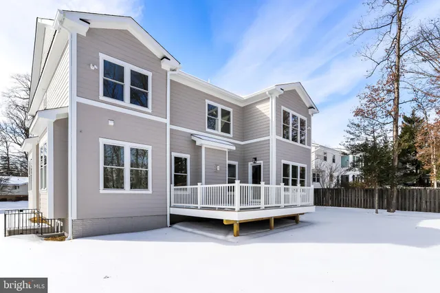 a view of a house with a wooden deck and a yard
