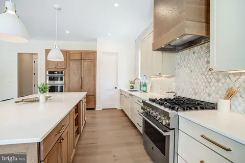 a kitchen with stainless steel appliances granite countertop a sink stove and cabinets