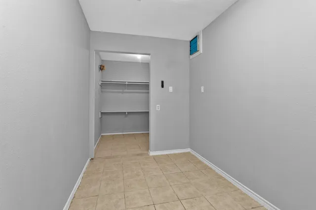 a view of walk in closet with empty racks