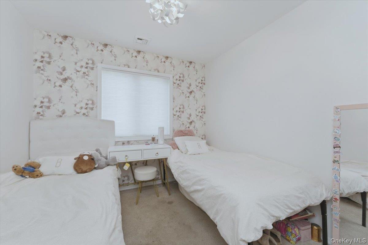 151 Wanser Avenue Inwood, NY 11096 - Photo 12 of 19 a bedroom with a bed and a chandelier