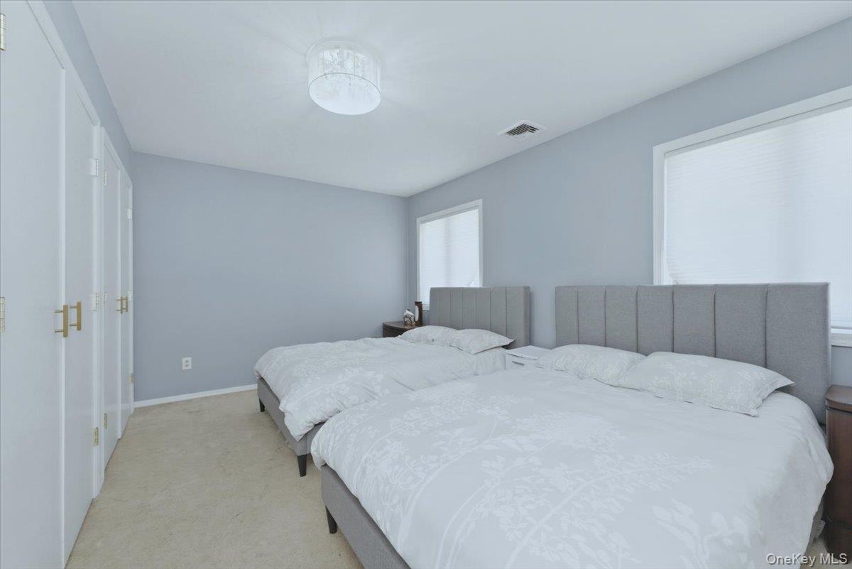 151 Wanser Avenue Inwood, NY 11096 - Photo 10 of 19 a bedroom with a bed and a chandelier