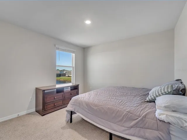 a bedroom with a bed dresser and a window