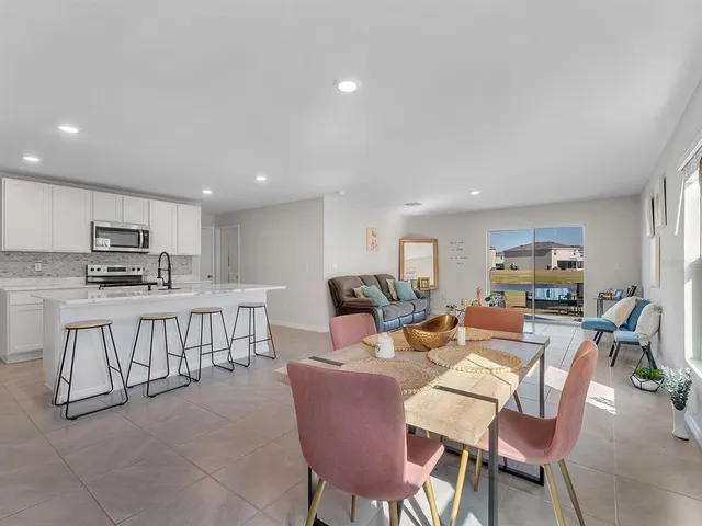 a living room with lots of furniture and kitchen view