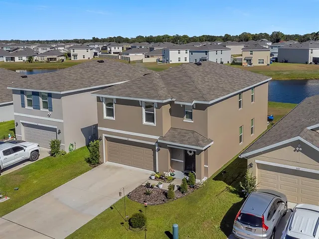 an aerial view of a house with a yard swimming pool and a fire pit