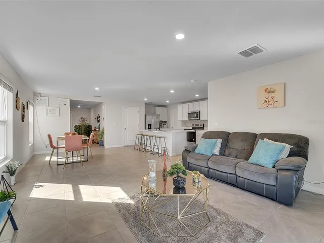 a living room with furniture and a view of kitchen